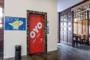 A hallway with a red door labeled 'OYO' and a map on the wall. - Yuanlin Hotel (Suzhou)