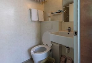 A bathroom with a toilet, sink, and towel rack. - Yuanlin Hotel (Suzhou)