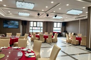 A conference room with multiple tables, chairs, and a large screen. - Fenghua International Hotel (Shengsi)