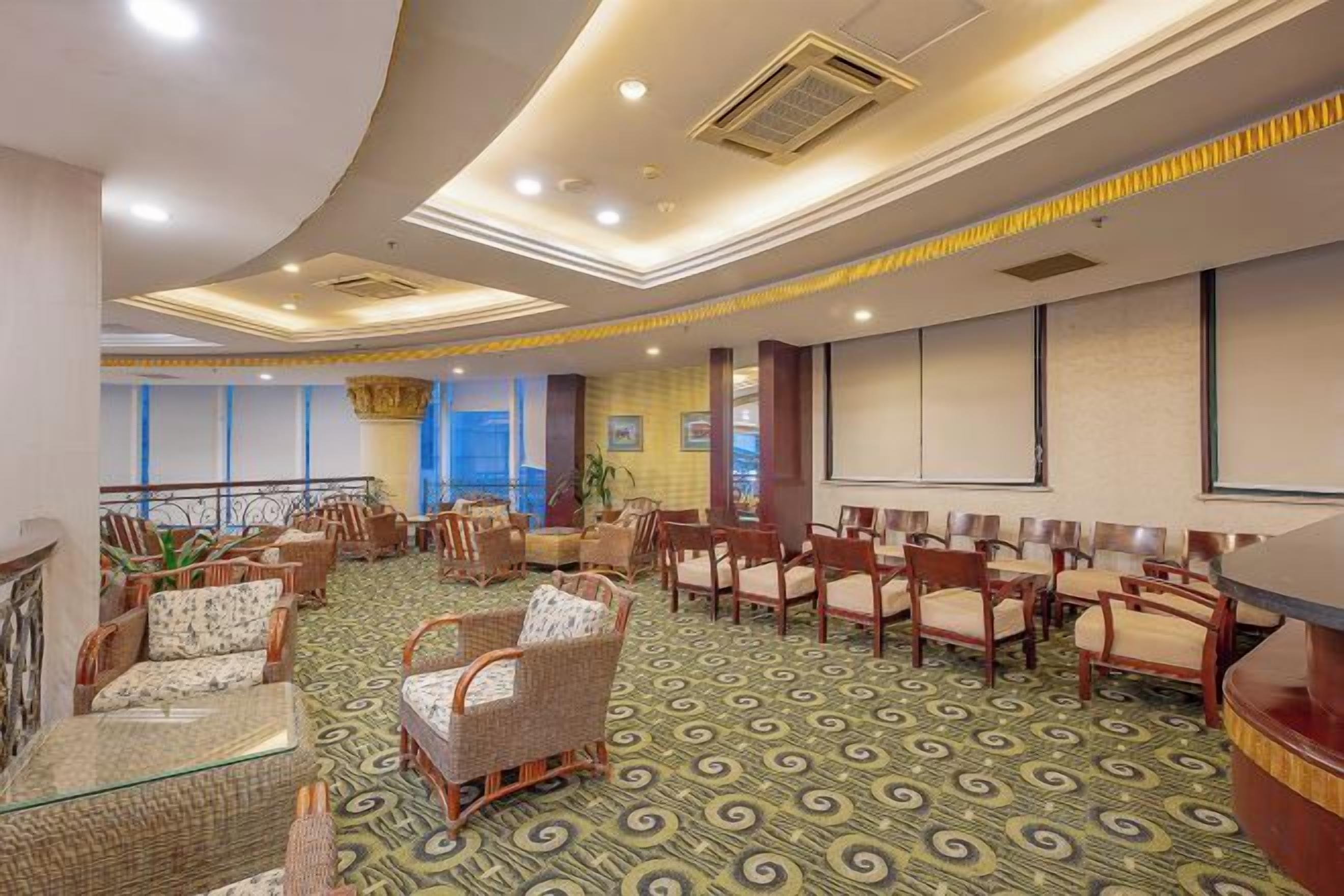 A conference room with a curved ceiling, multiple chairs, a stage, and a large screen.