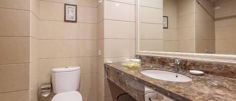 Un baño moderno con dos lavamanos, un espejo grande y un inodoro.