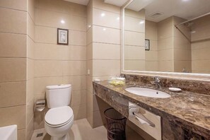 Un baño moderno con dos lavamanos, un espejo grande y un inodoro.