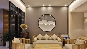A modern interior with a sofa, wooden chairs, a coffee table, and a decorative wall piece. - Friend Yue Hotel (Zhangjiajie Town Centre Huilong Road) (Zhangjiajie)