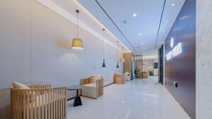 A modern lobby with a reception desk, seating area, and a wall with illuminated signage. - Friend Yue Hotel (Zhangjiajie Town Centre Huilong Road) (Zhangjiajie)