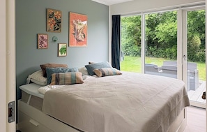 Ein Schlafzimmer mit Bett, Kissen und Wandbildern.