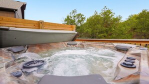 A hot tub with a wooden deck and a view of trees. - Hot Tub + Arcade -> Memorable Stay
 (Hollister)