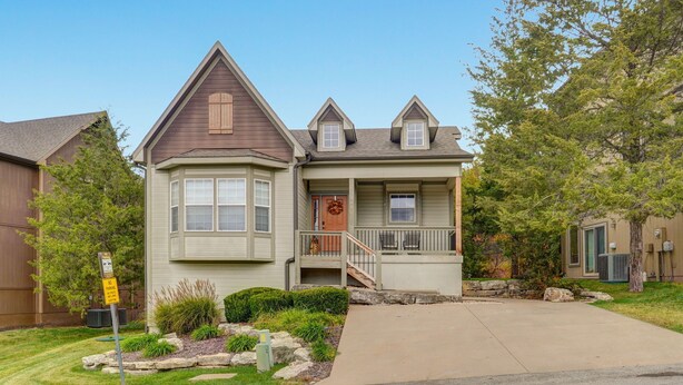 A two-story house with a front porch, a garage, and a driveway. - Hot Tub + Arcade -> Memorable Stay
 (Hollister)