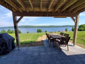 Enjoy dining and socializing on the patio with a barbecue grill and scenic views of the lake and surrounding forest.