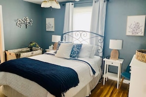 Un dormitorio con cama, mesitas de noche y velador.