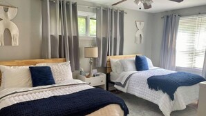 A hotel room with two beds, a ceiling fan, a window with curtains, and a wall-mounted lamp. - Dogtown St Louis Family & Pet Favorite!Yard, Barnes, SLU,WashU, Forest Park,Zoo (St. Louis)