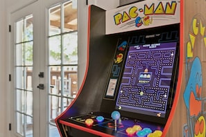 Ein Pac-Man Arcade-Automaten mit einem Labyrinthspiel, einem Punktestand-Anzeiger und einem Joystick.