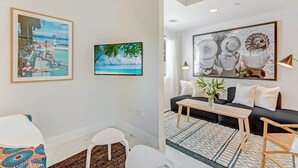 Ein modernes Wohnzimmer mit einer Couch, einem Couchtisch und Kunstwerken an den Wänden.