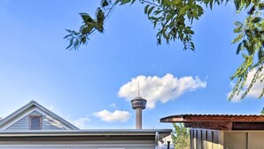 Ett hus med utsikt över ett torn i bakgrunden.
