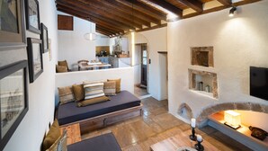 Una sala de estar acogedora con un sofá, una mesa de centro de madera y una chimenea.