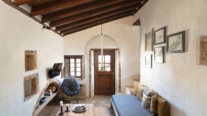 Una habitación acogedora con techo de madera, un sofá, una mesa de centro y una cama.