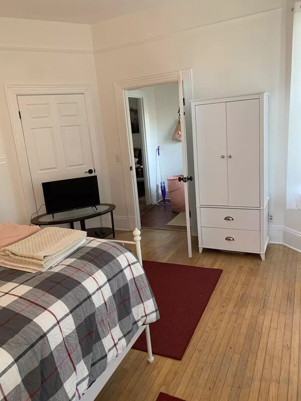 Relax in a cozy room with a neatly made bed, small table, and wardrobe.