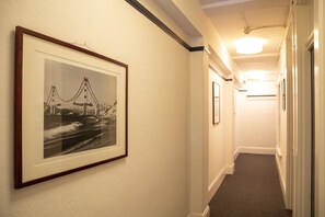 A hallway with a framed black and white photograph of a bridge on the wall.