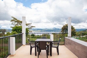 Enjoy a mountain view from this balcony with a table and four chairs.