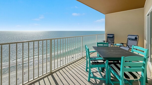 A balcony with a view of the beach and ocean.