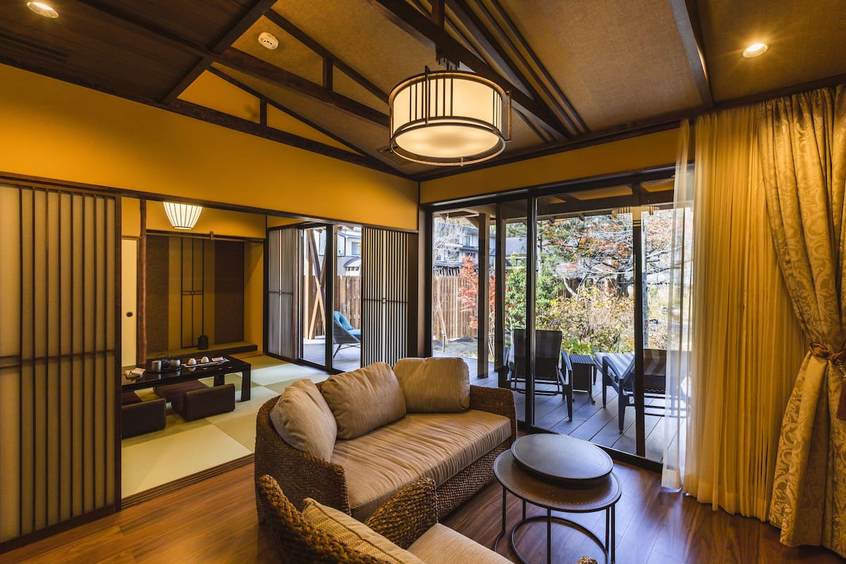 A traditional Japanese-style room with tatami flooring, a low wooden ceiling, and sliding doors.