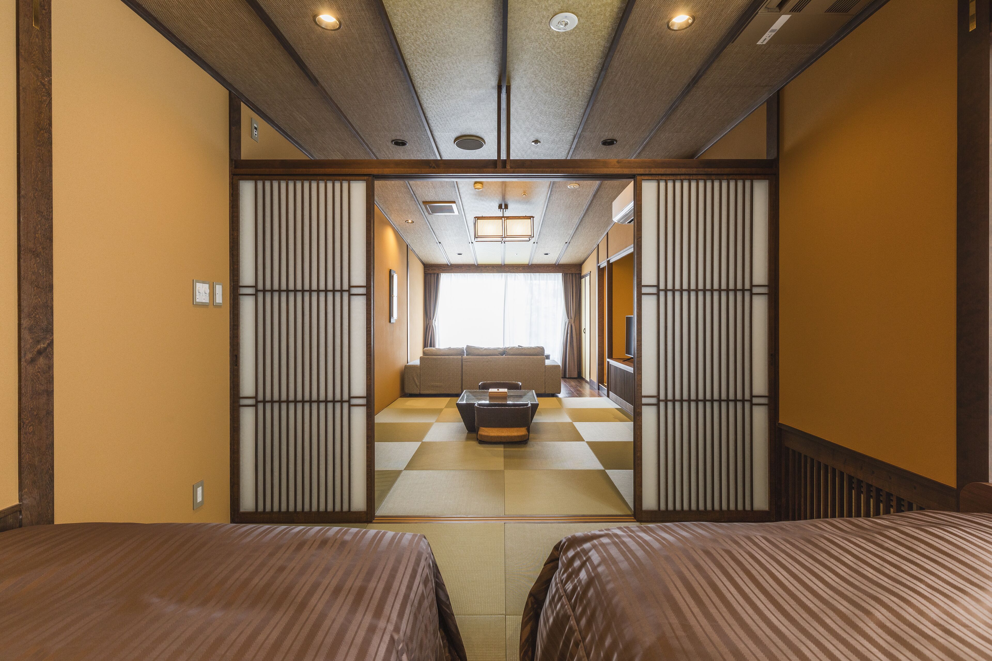 A traditional Japanese-style room with tatami flooring, a low table, and sliding doors.
