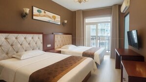 Ein Hotelzimmer mit zwei Betten, einem Fernseher, einem Gemälde und einem Balkon mit Blick.