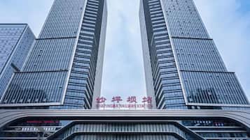 A tall building with a modern glass facade and a sign indicating a railway station.