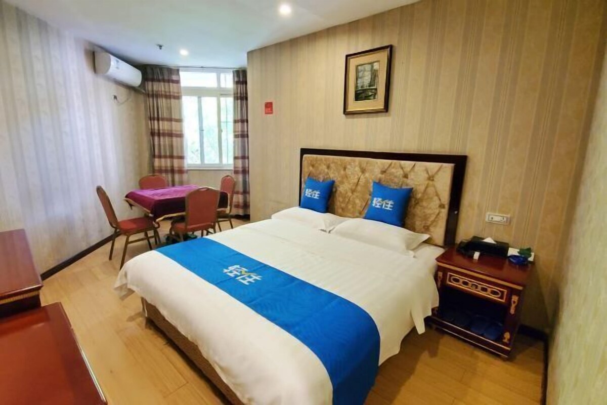 A hotel room with a bed, a desk, and a chair.