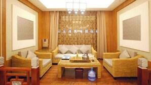 A room with a sofa set, a coffee table, and a large window with curtains. - Kai Bin Hotel (Baiyin)