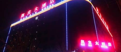Un hotel con señalización iluminada y una estructura curva distintiva.