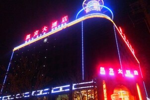 Un hotel con señalización iluminada y una estructura curva distintiva.