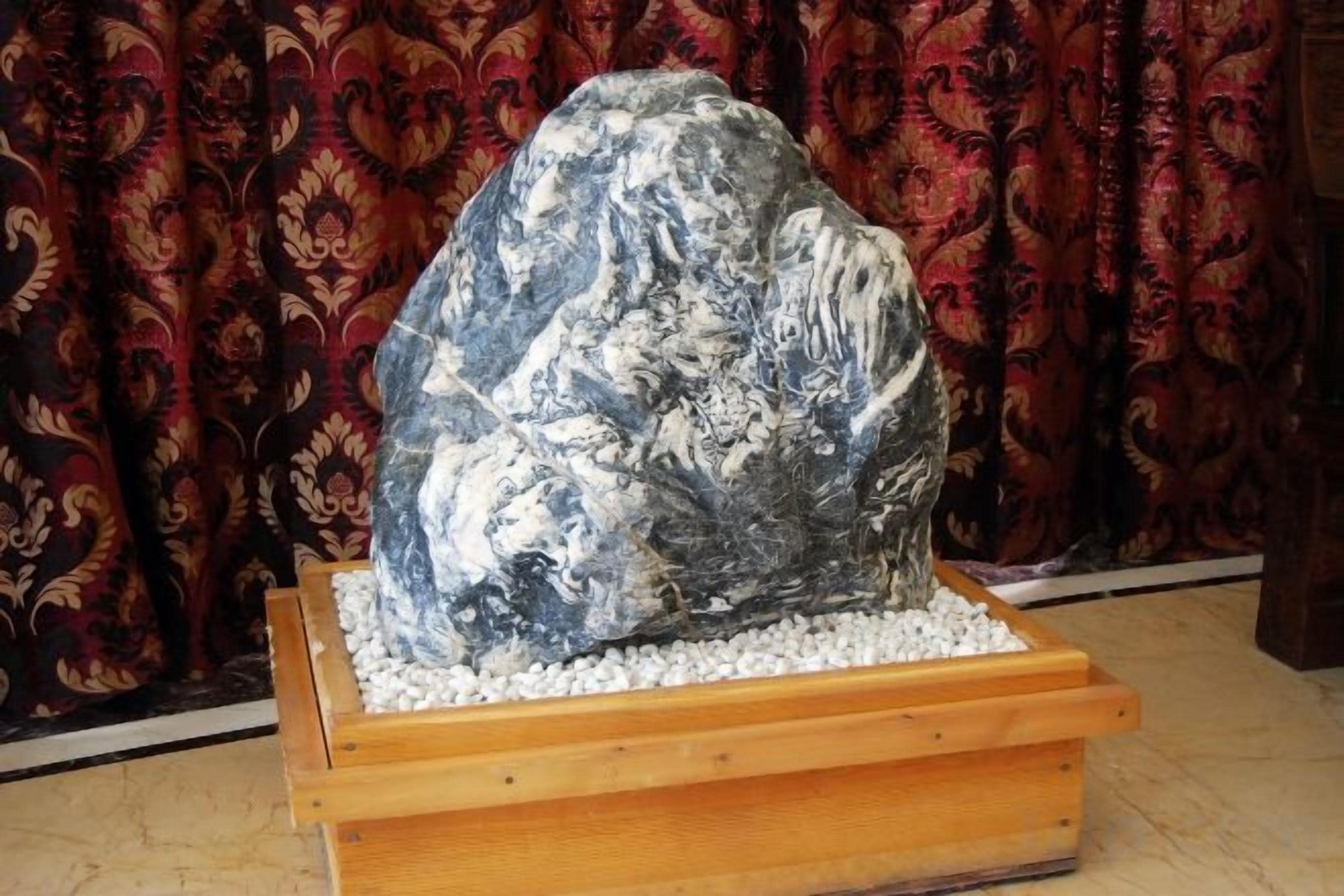 A large rock sculpture in a wooden display case.