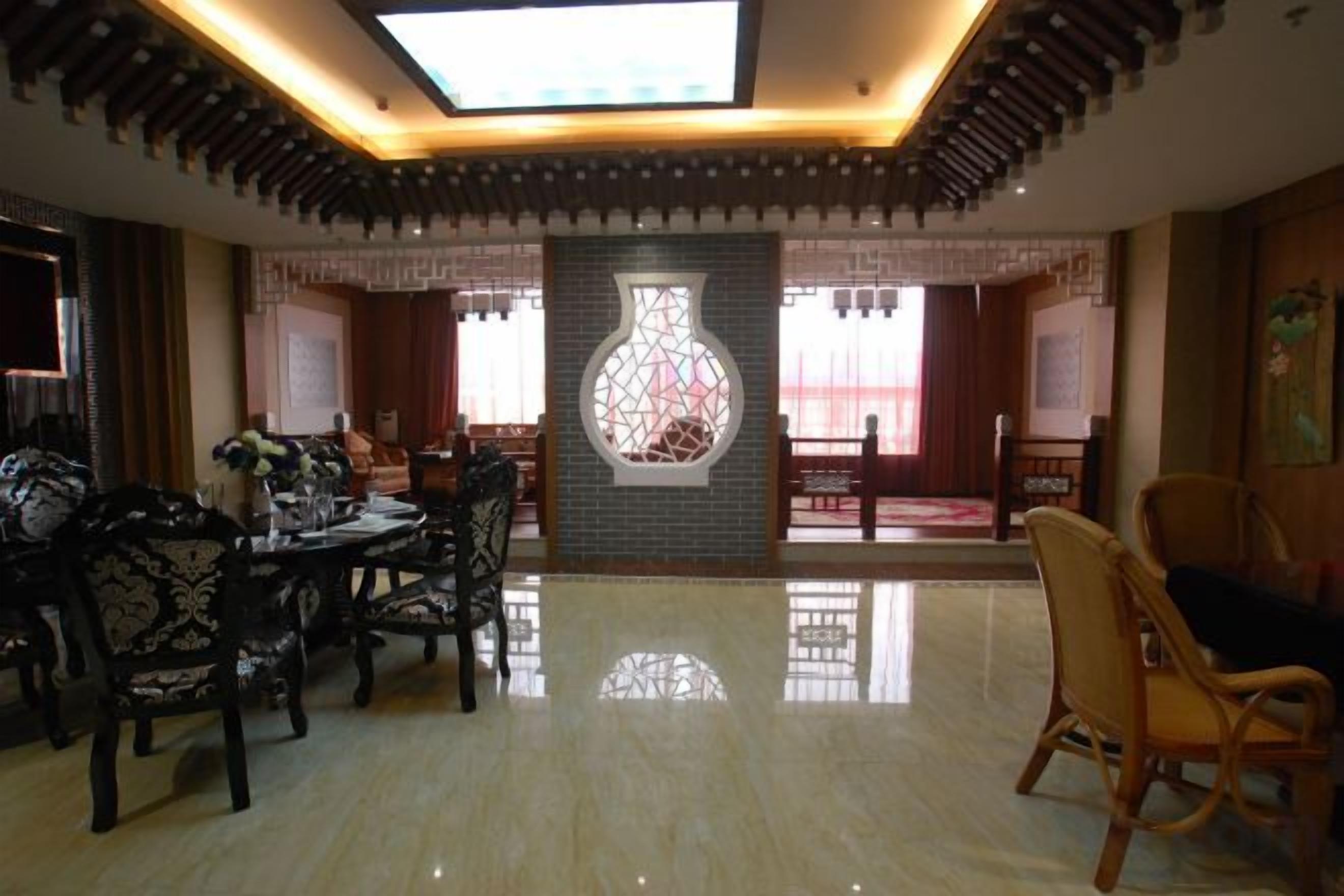 A spacious room with a dining area, a large vase decoration, and a view through a window.