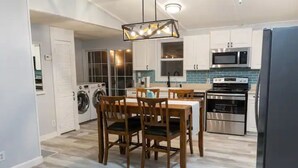 A modern kitchen with a dining area, built-in appliances, and a laundry room. - Serene Home with PRIVATE Pool - Near Beaches - Dog Friendly - Firepit&Large Yard (Freeport)