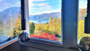 A kitchen with a view of a lake and mountains.
