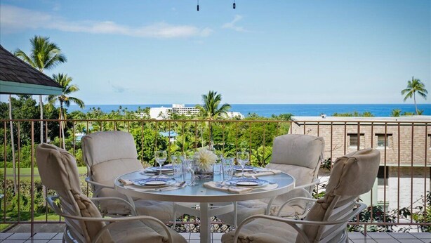A round table with four chairs on a balcony overlooking the ocean. - Ocean & Golf Course View Condo at Keauhou Akahi | 1 Bedroom + Murphy Bed (Kailua Kona)