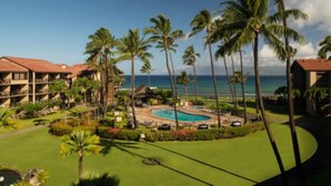 A resort with multiple buildings, a swimming pool, and palm trees.