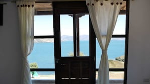 A room with a large window overlooking a body of water and hills. - Hotel Eliseo-Playa Blanca lago de Tota  (Tota)