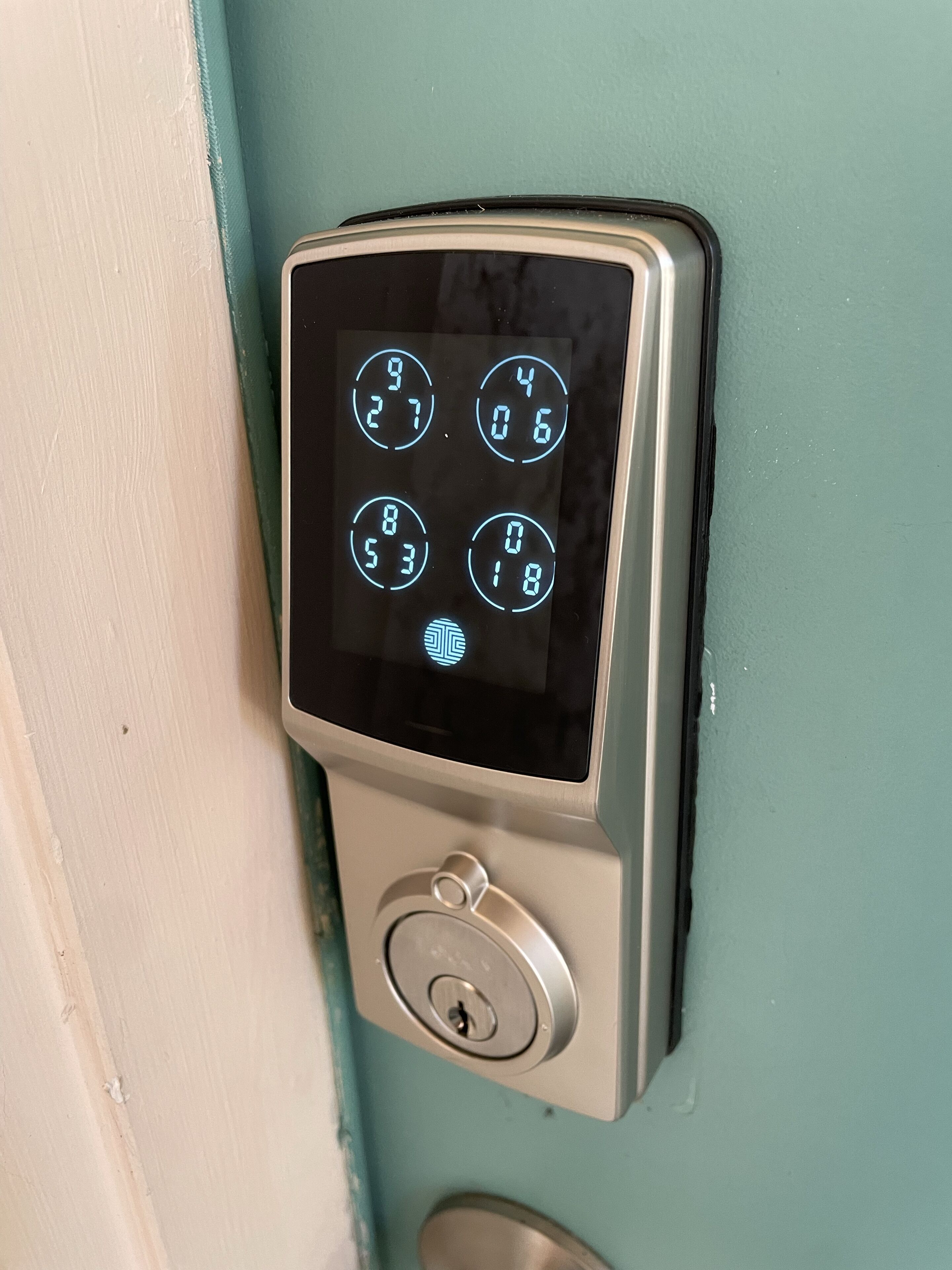 A keypad lock on a teal door.