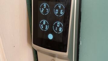 A keypad lock on a teal door.