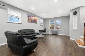 Relax in this inviting living space with a comfortable sofa, coffee table, and large window offering a view.