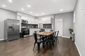Enjoy cooking in this well-equipped kitchen with a gas stove, microwave, and refrigerator, complemented by a dining table and chairs.