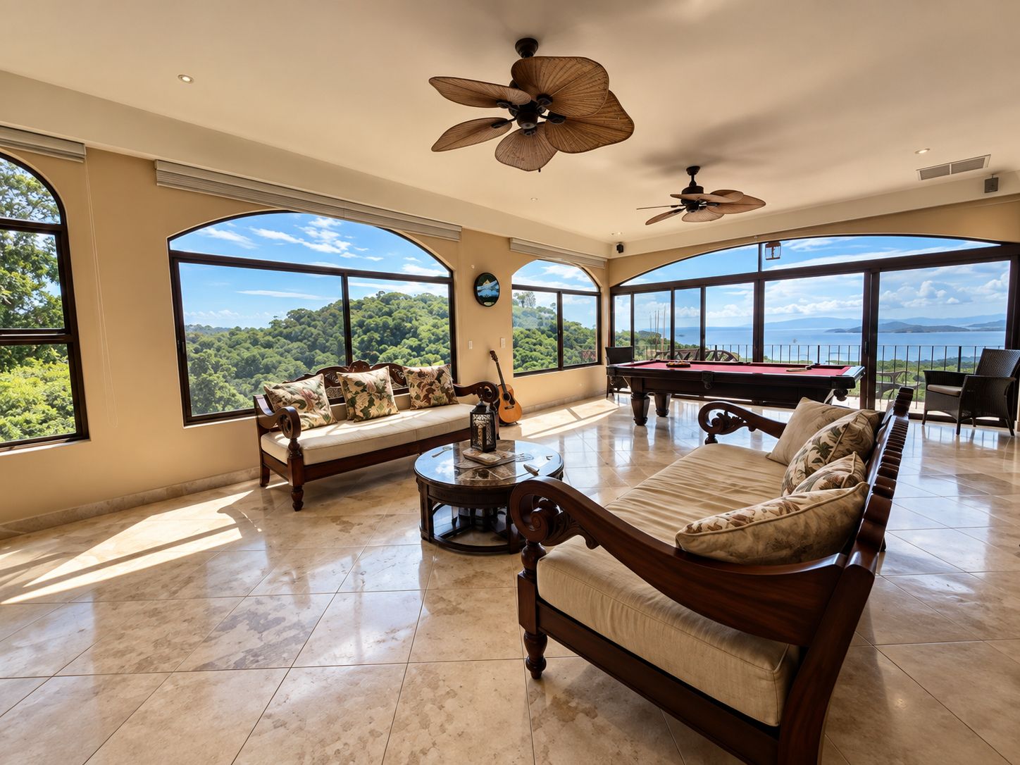A spacious living room with a pool table, two sofas, and large windows offering a view of the outdoors.