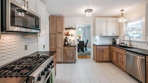 Una cucina moderna con elettrodomestici in acciaio inossidabile, mobili in legno e un'isola centrale.