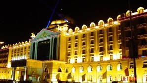 Un edificio grande e iluminado con una cúpula central y varios balcones.