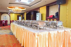 A banquet hall with a long table covered in a tablecloth, equipped with multiple serving stations. - Haishen Hot Spring Hotel (Arxan)