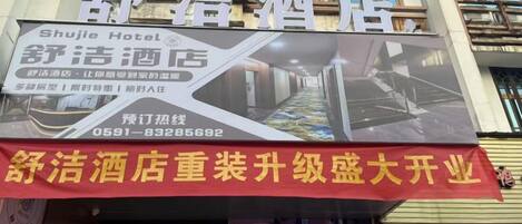 Un cartel de hotel con el nombre 'Shuju Hotel' e información de contacto.