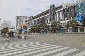 A city intersection with a pedestrian crossing, buildings, and a bus stop. - Shujie Hotel (Fuzhou)
