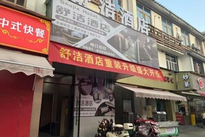 A hotel facade with signage indicating a restaurant and a room service number. - Shujie Hotel (Fuzhou)