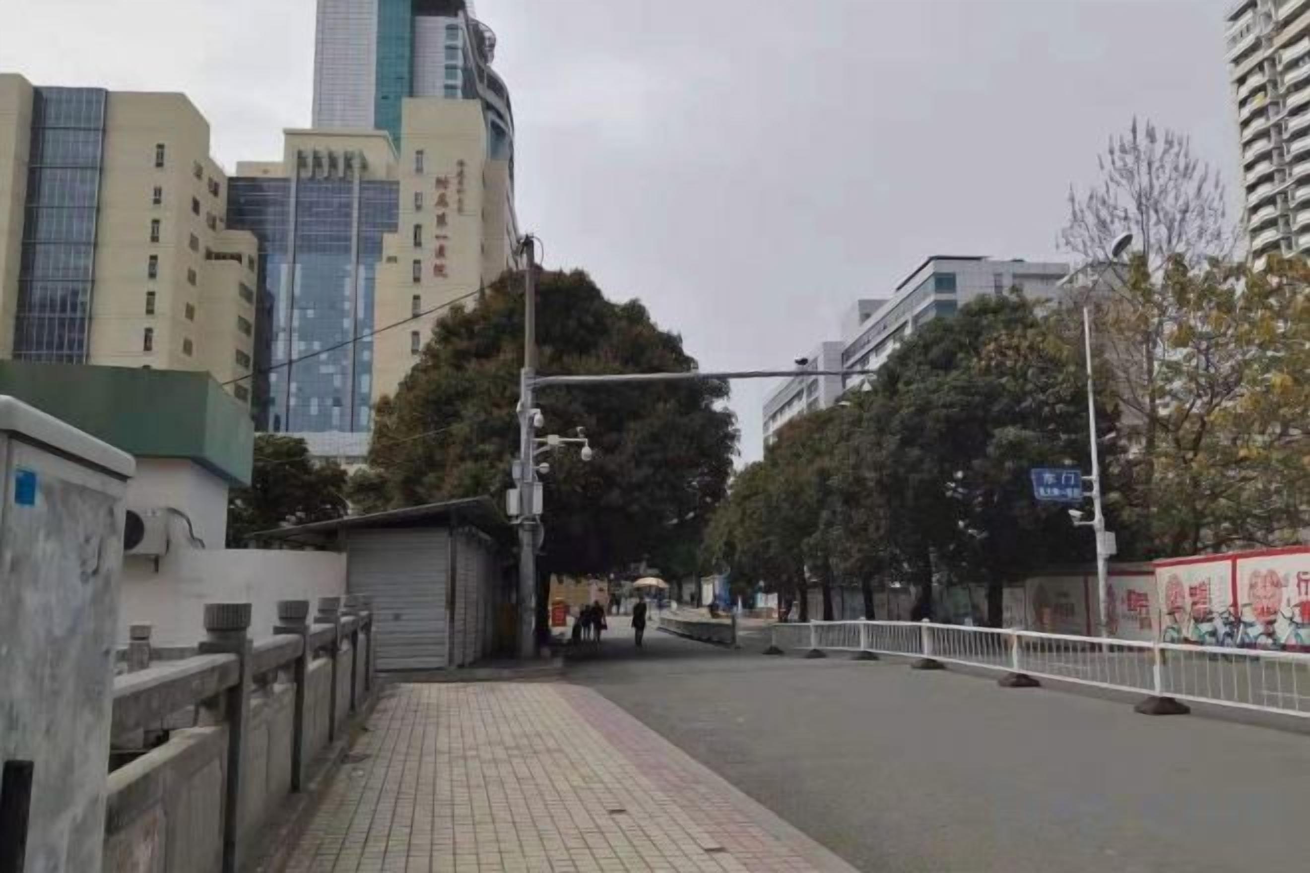 Una calle urbana con edificios, aceras y un paso de peatones.